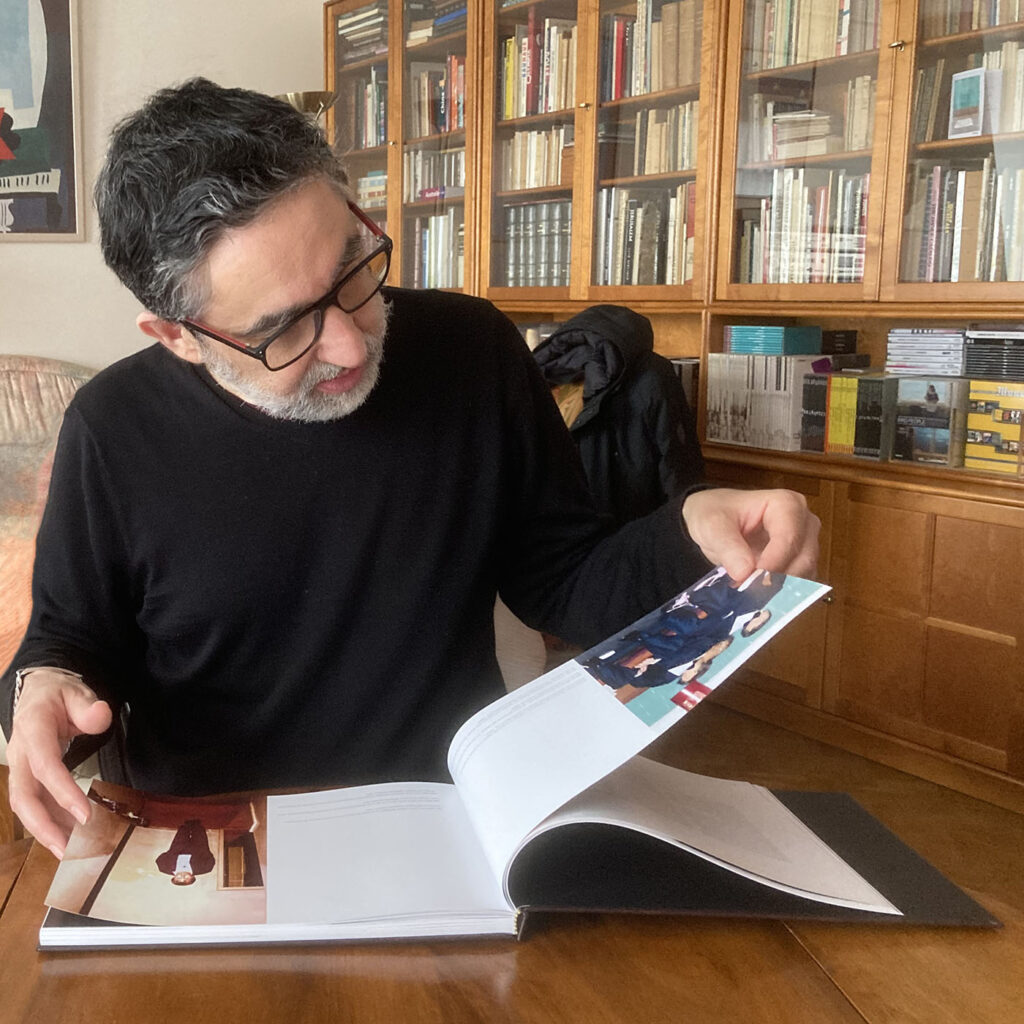 A man at a desk looks through a large-format book.